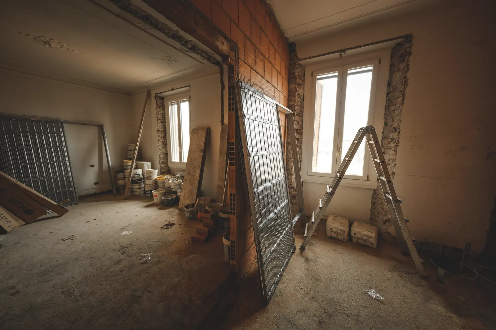 Le chantier commencé : nouvelle cloison en briques, échelle, matériaux livrés.
